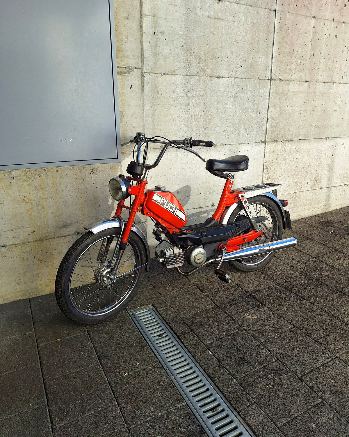 Rotes Puch Mofa vor Betonwand
