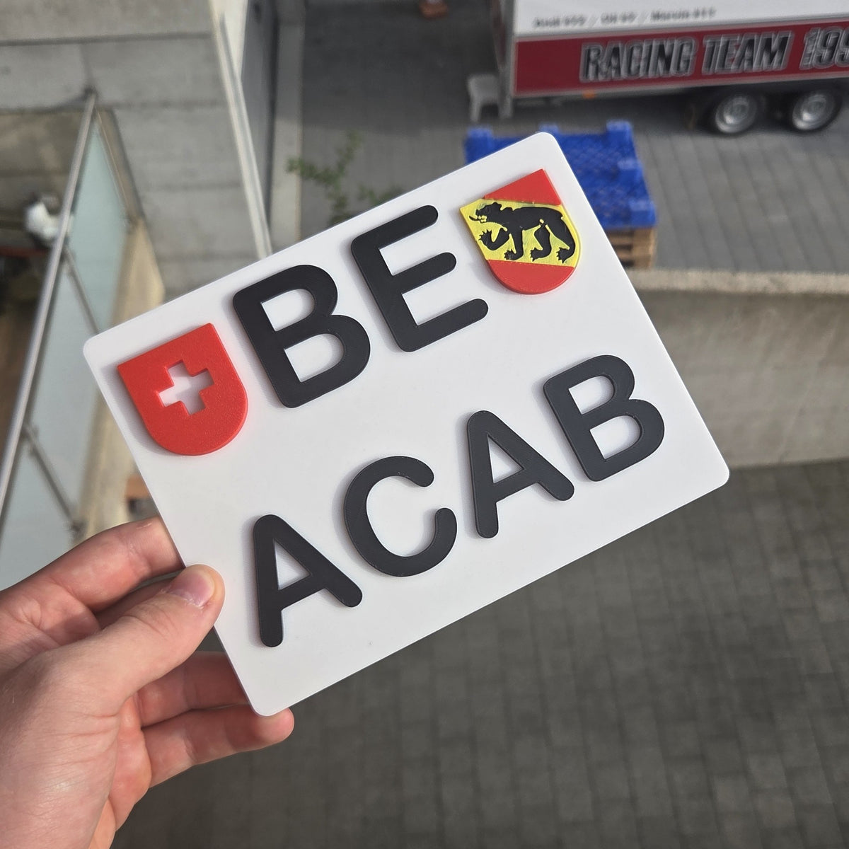 Deko-Kennzeichen ACAB in der Hand gehalten, zeigt die Groesse des Schilds